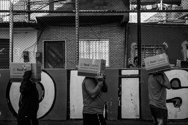 Residents carry boxes of donated food back home in the Paraisopolis slum in Sao Paulo. With the economic crisis caused by the coronavirus pandemic, many families have been left without any income, dep...