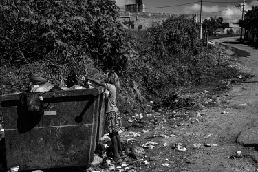 Agata, 7, scavanges through a rubbish bin in search of recyclable material to sell on a street on the outskirts of Sao Paulo. Because of the suspension of classes, due to the Covid-19 pandemic, many c...