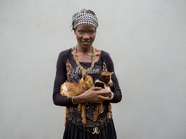 Esther Namoe (25), a Community Animal Health Worker (CAHW) who supports the Women's Livestock Group in Nawakorof B village holding goat kid twins that she is looking after as their mother was stolen i...