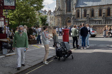 A couple with a newborn baby and an older man wearing a face mask among the people socialising in the street outside a pub in Notting Hill after easing of coronavirus lockdown restrictions enabled som...