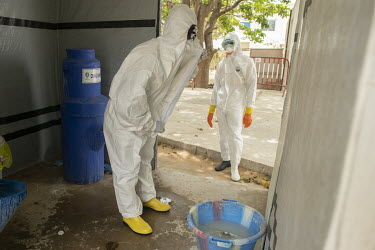 A cleaner carefully removes his protective clothing after his work in the area at the Fann university hospital where patients with COVID-19 are treated.