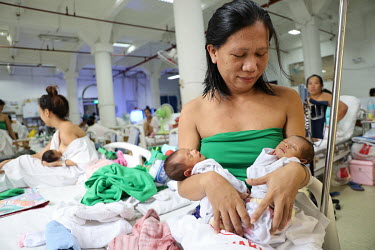 A mother with her newborn twins on a maternity ward at the Fabella Hospital.