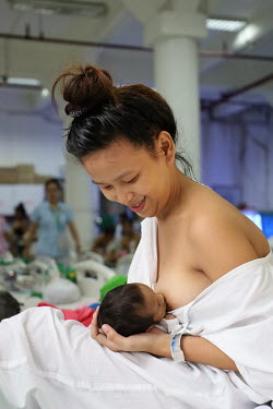 A mother breastfeeding her newborn baby on a maternity ward at the Fabella Hospital.