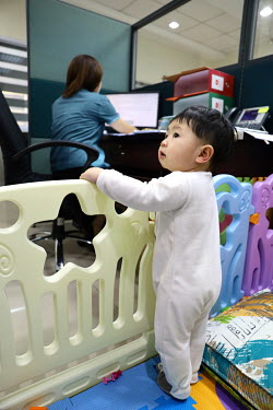 Julie Rose Dimaguiba with her 11-month-old-son Rijoff at her officein the Dept. of Health's head office. Not having anyone at home to support her she requested to take the child to the office, a reque...