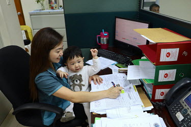 Julie Rose Dimaguiba with her 11-month-old-son Rijoff at her officein the Dept. of Health's head office. Not having anyone at home to support her she requested to take the child to the office, a reque...