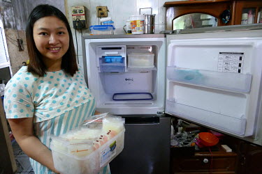 Htet Htet Thi (28) with expressed breast milk that she stores in a fridge at her home so her baby can be bottle fed when she is out at work during the day.