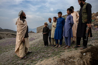 Commander Roja Gul (46) talking with village boys in an area under his control. Gul leads a group aligned with Mullah Manan Niazi's faction that has itself joined Mullah Rasool's splinter group 'The H...