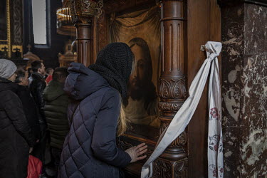 A woman kisses an icon as worshippers attend a morning service led by Patriarch Filaret at Kiev's Volodymyrsky Cathedral.