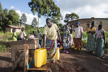 Women collecting drinking water from a source, installed by the Congolese NGO Centre d'Initation au Developpement Rural en Ituri (CIDRI).