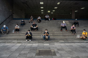 People, whose income has been negatively affected by the government's anti-coronavirus measures, wait, using social distancing protocols, on the steps outside the Ministry of Finance building to regis...