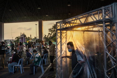 People crossing onto Phuket island via the Thao Thepkrasattri Bridge are sprayed with a disinfectant in a decontamination tent at a checkpoint in Chatchai. The governor of Phuket put restrictions on l...
