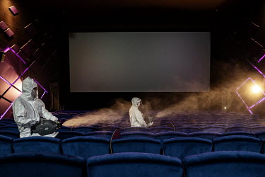 Cleaners disinfect a cinema which was due to reopen the following day as the government eased coronavirus lockdown restrictions.
