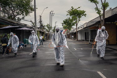 Cleaners, wearing ppe, spray disinfectant during a deep clean of Chatuchak Market, which was due to reopen the following day as the government eased coronavirus lockdown restrictions.