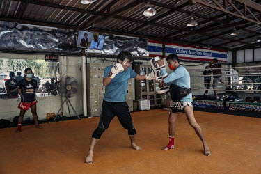 An instructor, wearing a face mask, spas with a student, wearing a face shield, at a Thai boxing gym, that was allowed to re-open on 1 June 2020 as the government eased coronavirus lockdown restrictio...