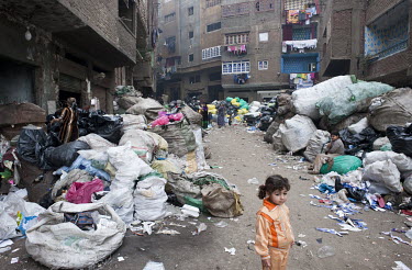 A child stands among sacks of rubbish in Muqattam, a poor Christian suburb whose inhabitants are known as the Zabaleen, a minority community of Coptic Christians who have for many years served as the...
