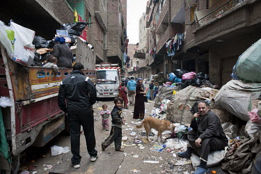People gather among sacks of rubbish in Muqattam, a poor Christian suburb whose inhabitants are known as the Zabaleen, a minority community of Coptic Christians who have for many years served as the c...