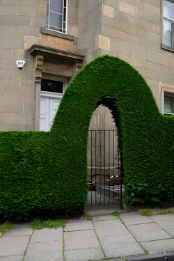 A topiary archway over a house entrance in Stockbridge.  Hedges offer increased privacy, isolating the homeowner and emphasising the division of public and private space. Where boundaries between prop...