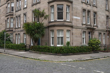 A palm tree and small border hedge outside a tenement flat in Stockbridge.  Hedges offer increased privacy, isolating the homeowner and emphasising the division of public and private space. Where boun...
