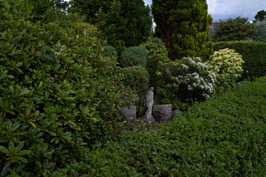 A garden statue hidden among shrubs and hedges in Blackhall.  Hedges offer increased privacy, isolating the homeowner and emphasising the division of public and private space. Where boundaries between...