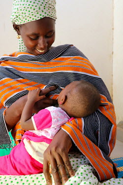 A woman breastfeeds her young child at a Primary Health Care Unit.