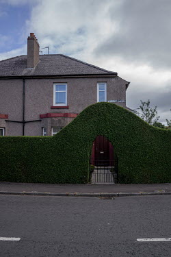 An archway formed from border hedge in Granton.  Hedges offer increased privacy, isolating the homeowner and emphasising the division of public and private space. Where boundaries between properties m...