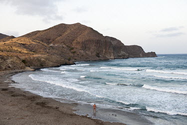 A naked man looking out over the Mediterranean Sea near La Isleta del Moro or the Moorish Island at Cabo de Gata Natural Parc.