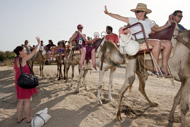 Tourists on a camel trip along the Mediterranean coast.