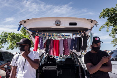 People sell face masks from the boot of their car outside a shopping centre in Khayelitsha.