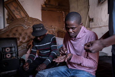 Youths smoke a cheap form of crystal methamphetamine known locally as 'tik' at a house during the coronavirus lockdown.