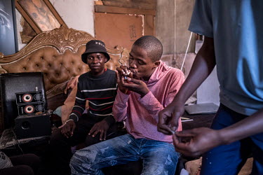 Youths smoke a cheap form of crystal methamphetamine known locally as 'tik' at a house during the coronavirus lockdown.