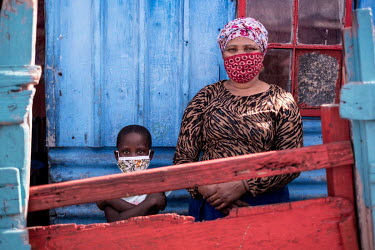 Noluvuyo Gadela and her six year old daughter, Siamtanda, look over the front gate outside their home in the township of Khayelitsha. Gadela, who supported the family by selling grilled meat on the st...