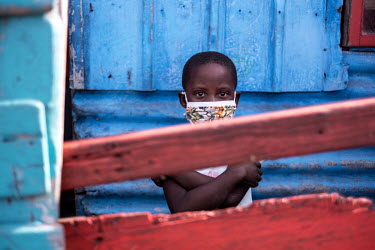 Six year old Siamtanda Gadela looks over the front gate outside her home in the township of Khayelitsha. Gadela's mother, who supported the family by selling grilled meat on the street, has been force...