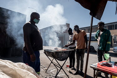 Men grilling meat at a street stall in Nyanga. The stand was previously destroyed by police for breaching coronavius restrictions, but the owner felt there was no choice but to reopen anyway, in order...