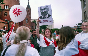 A protestor holds a photo of Lukashenko with a slogan that reads: 'We are not your slaves'. More than 100,000 protesters were involved in the rally in central Minsk where there were demands for the re...
