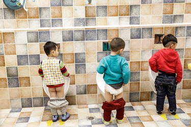 Infants using the urinals in a kindergarten (creche) catering to employees of travel company Ctrip.com (part of the Trip.com Group Ltd.) at their headquarters in the Sky Soho building.