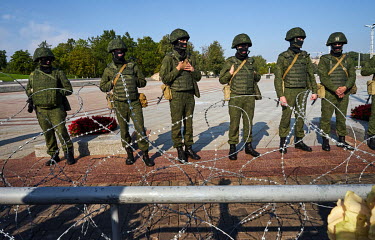 Conscripted troops stand behind a barbed wire baricade near the Stela Minsk Hero City during one of the ongoing mass protests in the city centre where the demand was for the resignation of the authori...