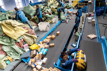 Workers sort and monitor packages on a conveyor belt at a ZTO Express Inc. sorting facility. Package delivery billionaires, including the founder of ZTO Express, have seen their fortunes swell as onli...