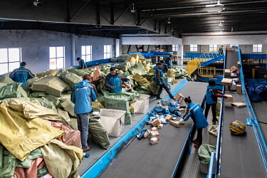 Workers sort and monitor packages on a conveyor belt at a ZTO Express Inc. sorting facility. Package delivery billionaires, including the founder of ZTO Express, have seen their fortunes swell as onli...