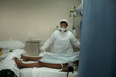 A nurse attending a critically ill patient who is suffering from COVID-19 in the intensive care unit of the Hospital Brasilandia.