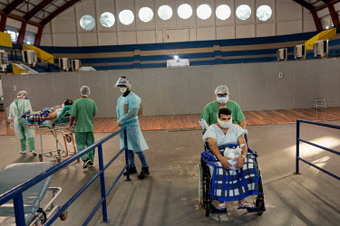 A new COVID-19 patient arrives (Left) as Pedro Rodrigues de Freitos (49) is finally discharged after his recovery from COVID-19.  The hospital is in an indoor stadium temporarily converted into a fi...