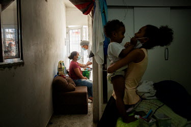 Jennifer (10) plays with her two year old brother Moises while their mother, Vanessa Silva Santos Souza, is tested for COVID-19 antibodies in their apartment in the Paraisopolis favela. A team of volu...