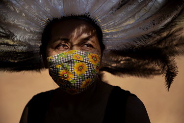 Loyre, an indigenous Terena woman from the village of Bananal, wearing a traditional feather headdress. She is the sister of the community's latest COVID-19 victim, teacher Saulo Francisco, is wearing...