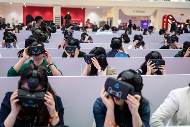 Members of the media wear virtual reality headsets, featuring the Tmall Cat mascot for Alibaba Group Holding Ltd.'s Tmall online marketplace, at Alibaba's annual November 11 Singles' Day online shoppi...