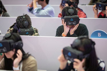 Members of the media wear virtual reality headsets, featuring the Tmall Cat mascot for Alibaba Group Holding Ltd.'s Tmall online marketplace, at Alibaba's annual November 11 Singles' Day online shoppi...