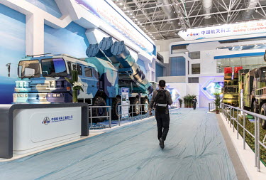 A visitor walks past a mobile missile and rocket launcher on display at the China International Aviation & Aerospace Exhibition.