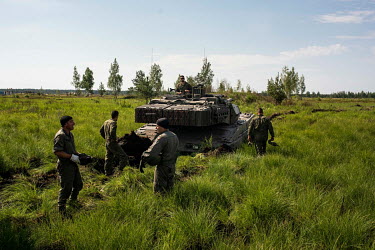 NATO ground forces conducting military exercisesfrom the Adazi military base try to extract a tank stuck in marshy soil.