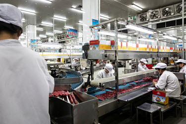 Employees working on a production line sort and package 'Shuanghui' branded sausages made from imported pork meat, supplied by Smithfield Foods Inc., at a WH Group Ltd. facility. As China prohibits im...