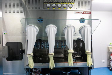 Gloves hang from the door of an isolation chamber in a quality control laboratory at a China Grand Pharmaceutical and Healthcare Holdings Ltd. facility.