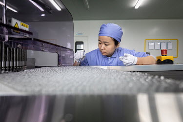 An employee examines vials of adrenaline hydrochloride injection solution at a China Grand Pharmaceutical and Healthcare Holdings Ltd. facility.
