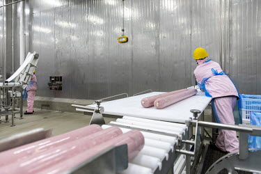 An employee handles packages of imported pork meat, supplied by Smithfield Foods Inc., on a production line at a WH Group Ltd. facility that processes the pork into ham. As China prohibits imports of...